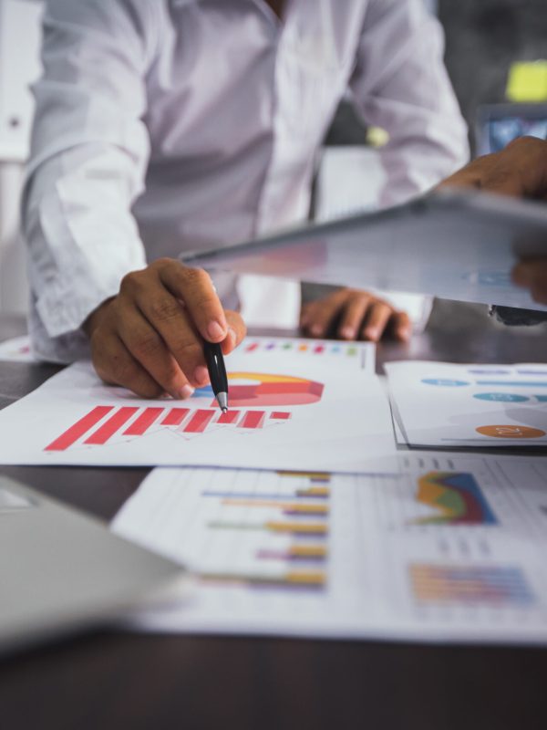 group of business people planning and analysis with financial graph paper and check in tablet, team of marketing and accounting concept
